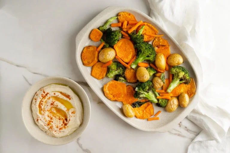 Plat de légumes au four avec carottes oranges, brocolis verts, pommes de terre et patates douces rôtis à l'huile d'olive sur plaque de cuisson
